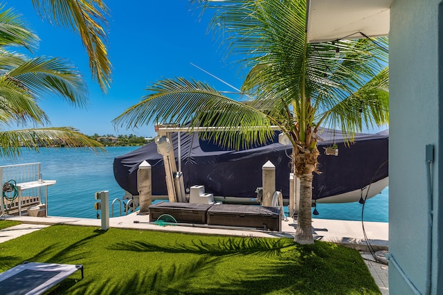 view of dock with a water view and a lawn