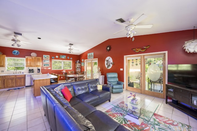 living room featuring ceiling fan, lofted ceiling, and light tile patterned floors