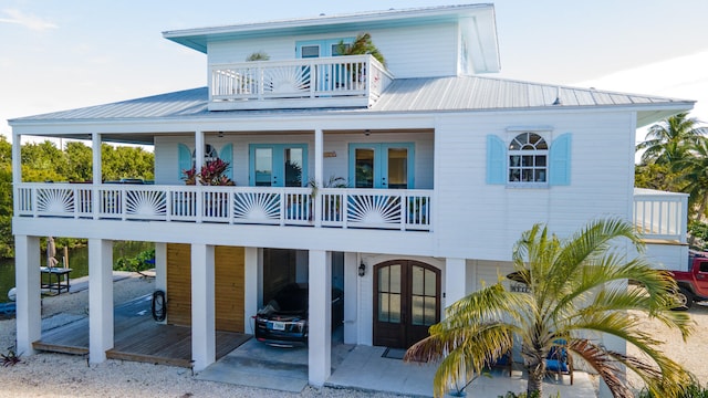 back of property featuring a balcony, a patio area, and french doors