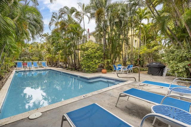 view of pool featuring a grill and a patio