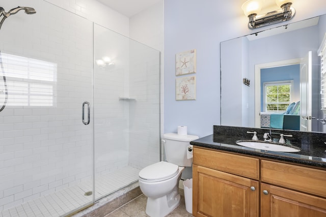 bathroom featuring vanity, toilet, tile patterned flooring, and a shower with door