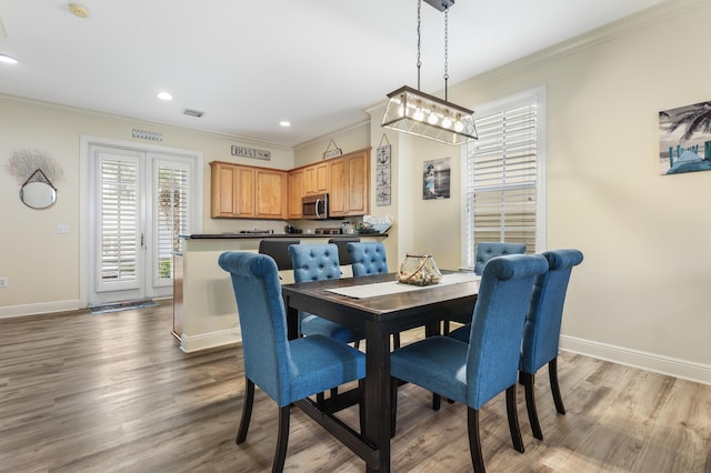 dining area featuring hardwood / wood-style flooring and crown molding