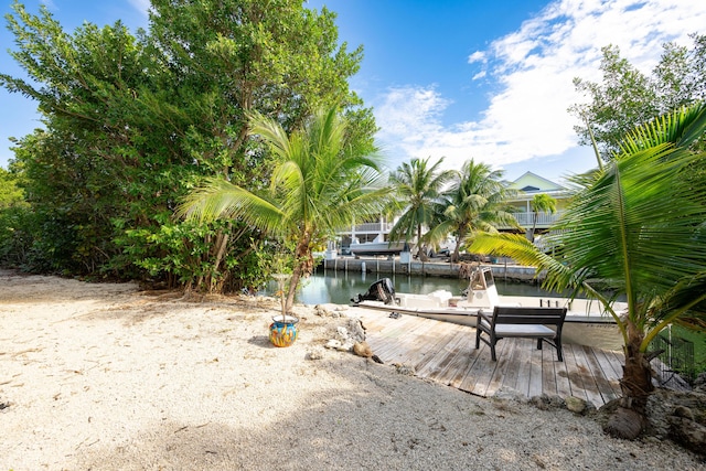 view of yard with a water view and a dock