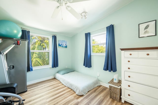 bedroom featuring ceiling fan, lofted ceiling, and light hardwood / wood-style flooring