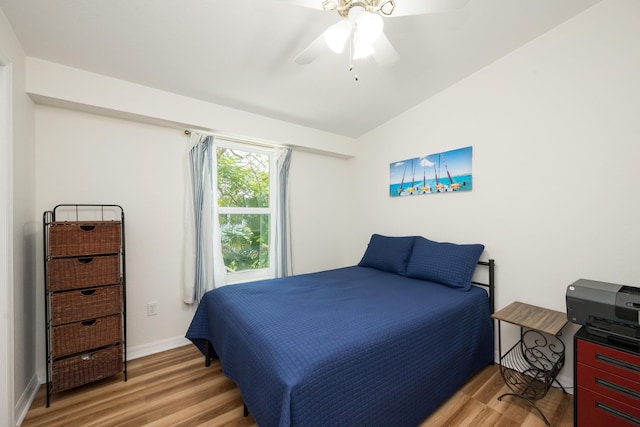 bedroom featuring ceiling fan, wood-type flooring, and vaulted ceiling