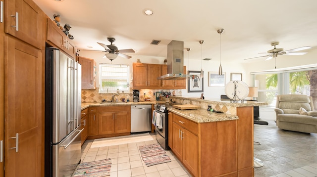 kitchen featuring appliances with stainless steel finishes, backsplash, island range hood, a kitchen bar, and decorative light fixtures