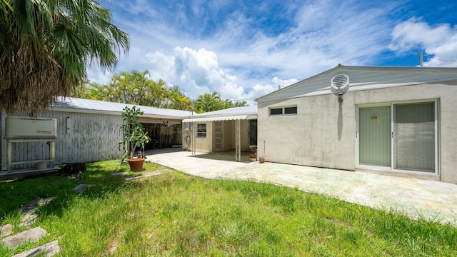 rear view of house featuring a patio and a yard