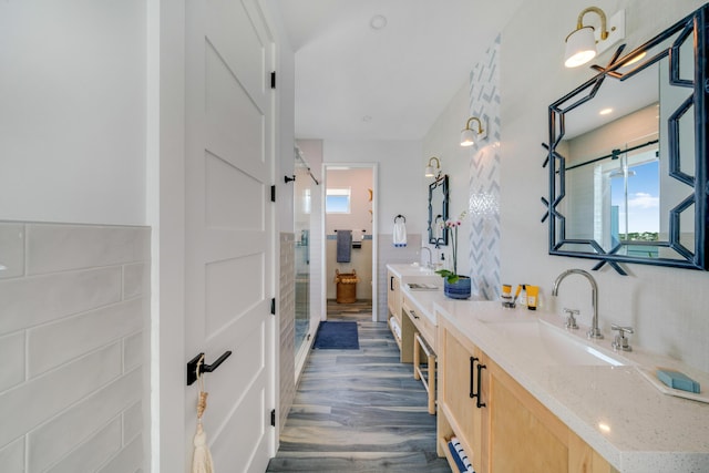 bathroom with vanity, hardwood / wood-style floors, tile walls, and a shower with shower door