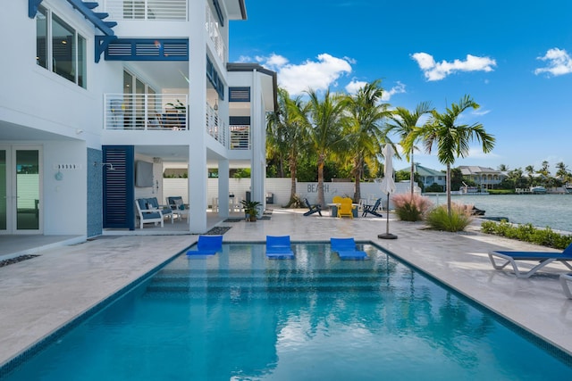 view of pool with a water view and a patio