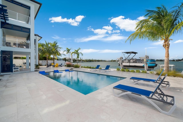 view of pool featuring a water view and a patio area