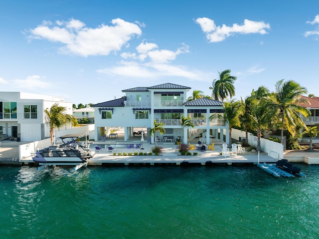 back of property featuring a balcony and a water view