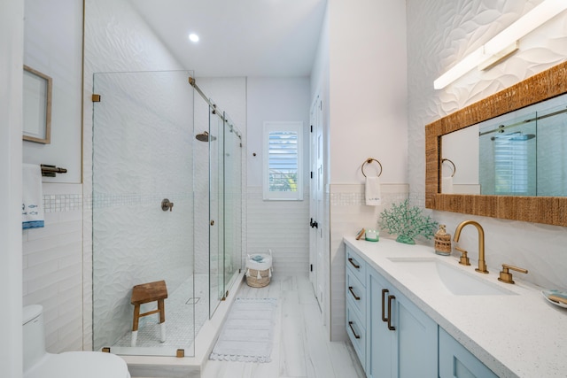 bathroom featuring tile walls, vanity, toilet, and an enclosed shower