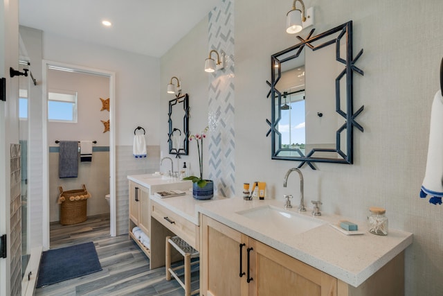 bathroom with hardwood / wood-style floors, vanity, tile walls, and toilet