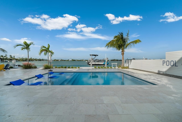 view of pool with a water view and a patio area