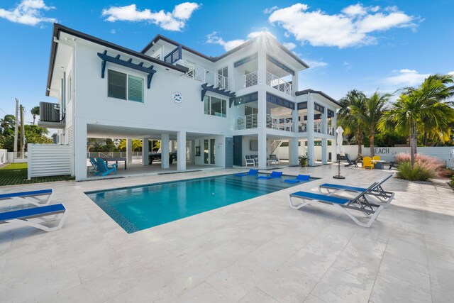 back of house featuring central AC unit, a fenced in pool, and a patio