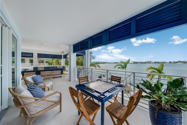 view of patio featuring an outdoor living space, a balcony, and a water view