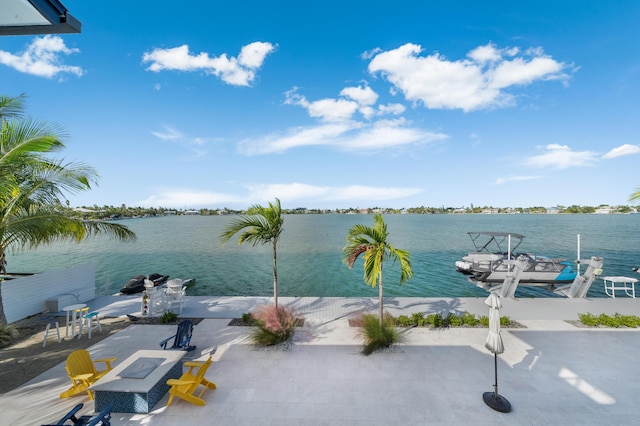 dock area featuring a patio, a water view, and an outdoor fire pit