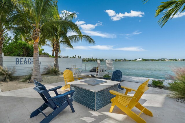 view of patio featuring an outdoor fire pit and a water view