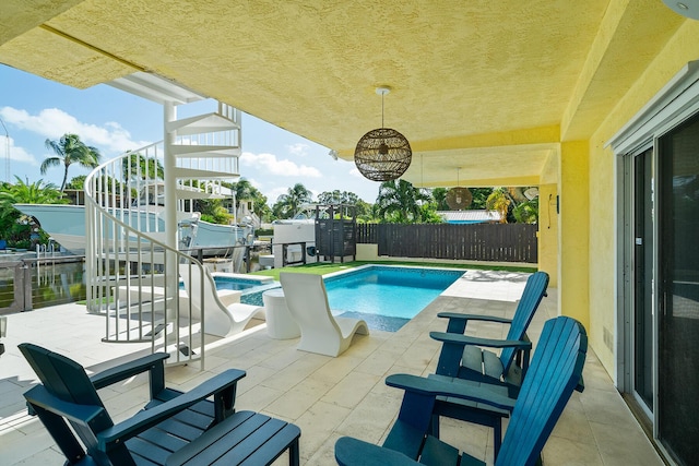 view of pool with a jacuzzi and a patio