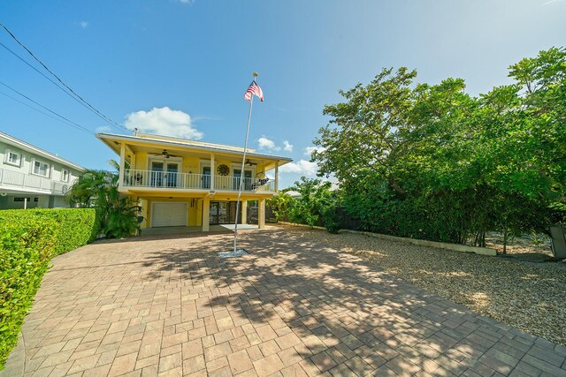 view of front of home featuring a garage, a balcony, and ceiling fan