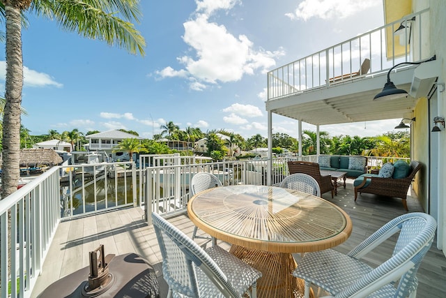 balcony with an outdoor hangout area and a water view