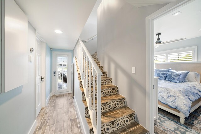 stairs featuring hardwood / wood-style floors and ceiling fan