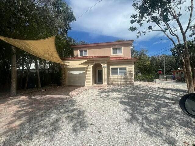mediterranean / spanish-style home with driveway and fence