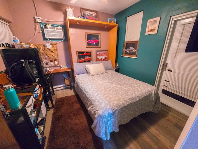 bedroom featuring wood finished floors and a wall mounted AC