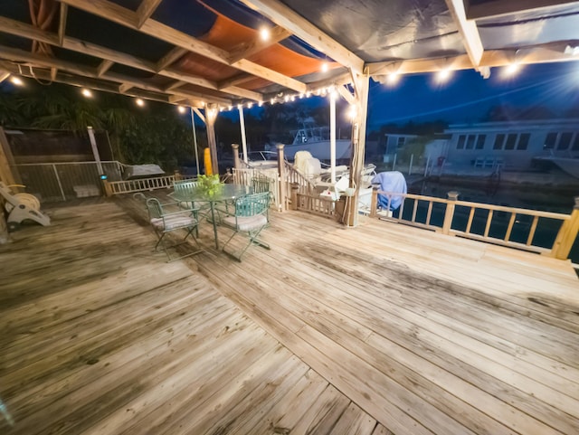 deck at twilight featuring outdoor dining area