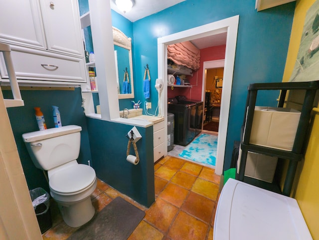 bathroom featuring vanity, toilet, and separate washer and dryer