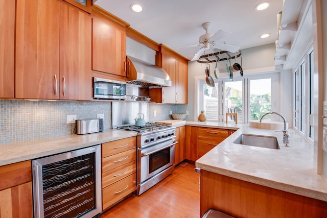 kitchen with sink, stainless steel appliances, extractor fan, decorative backsplash, and beverage cooler