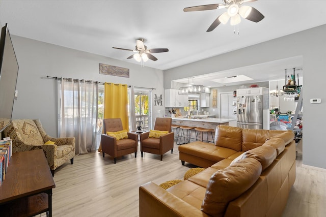 living room with ceiling fan and light hardwood / wood-style flooring