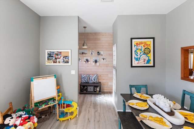 playroom with hardwood / wood-style floors and wooden walls