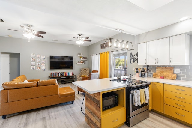 kitchen with stainless steel electric range oven, light hardwood / wood-style flooring, kitchen peninsula, white cabinets, and backsplash