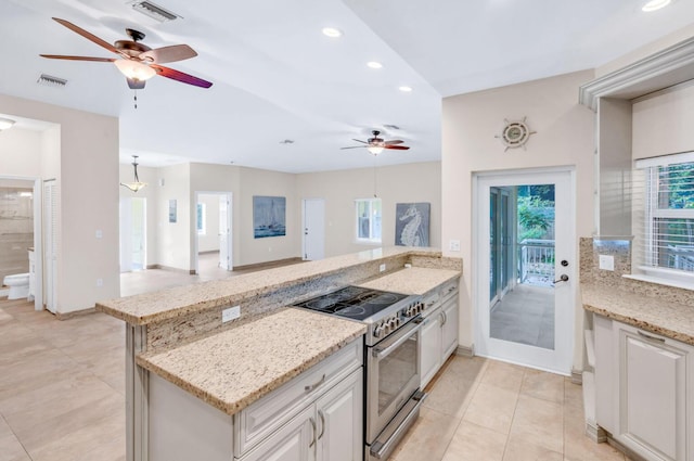 kitchen featuring stainless steel electric range oven, light stone countertops, kitchen peninsula, and decorative light fixtures