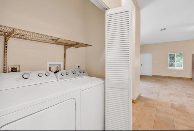 clothes washing area featuring light tile patterned flooring and washer and clothes dryer