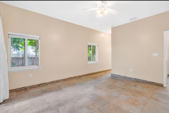 spare room with ceiling fan and a wealth of natural light