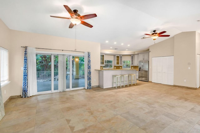 unfurnished living room featuring ceiling fan and lofted ceiling