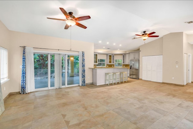 unfurnished living room with vaulted ceiling and ceiling fan