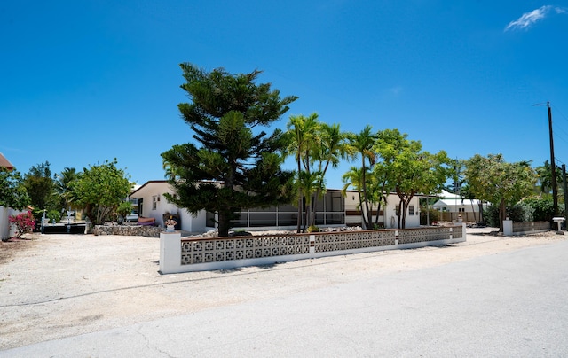 214 Pueblo St, Tavernier, FL 33070 - view of property hidden behind natural elements with a fenced front yard and stucco siding
