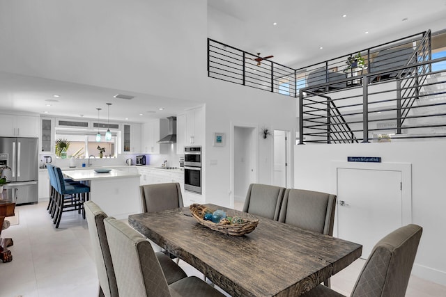 tiled dining room with sink and a towering ceiling