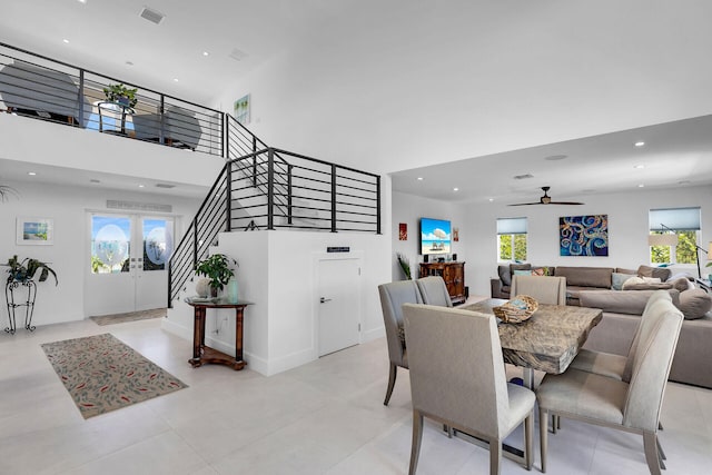 dining space with a high ceiling, ceiling fan, and french doors