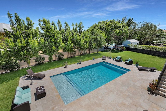 view of pool with an outdoor living space, a lawn, and a patio area