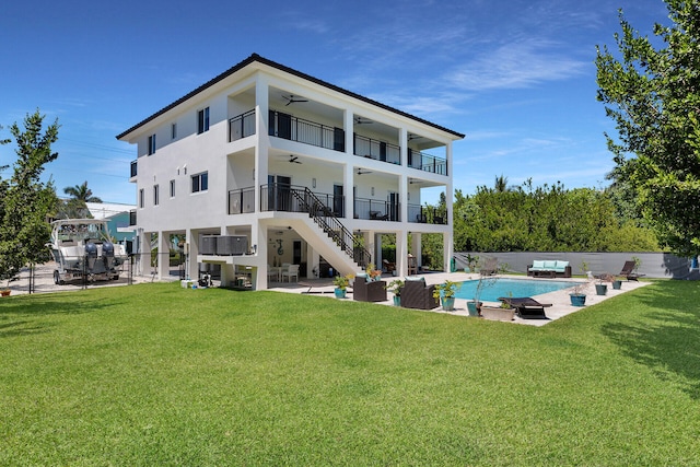 rear view of property featuring ceiling fan, a fenced in pool, a balcony, and a patio