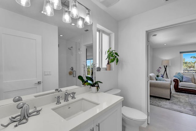 bathroom featuring vanity, a shower with door, and toilet