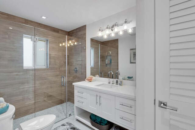 bathroom with vanity, toilet, and a shower with shower door