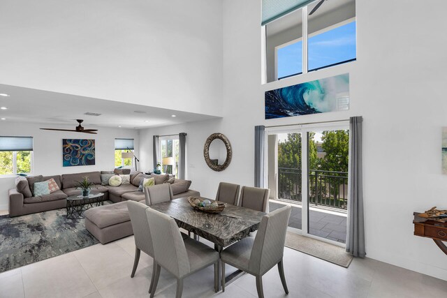 tiled dining area featuring a towering ceiling and ceiling fan