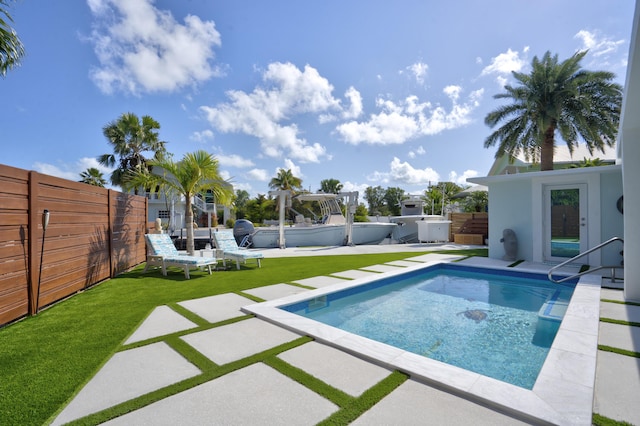 view of swimming pool with a patio and a yard