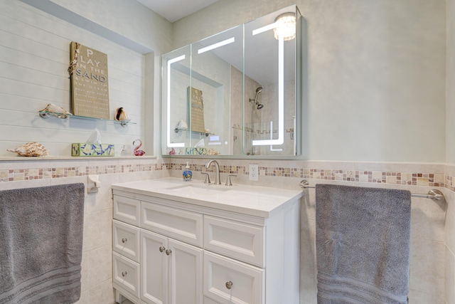 bathroom featuring vanity and tile walls