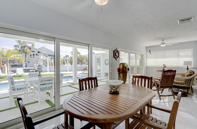 dining room with ceiling fan and a textured ceiling